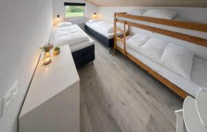 a room with two beds and a desk with two beds at Nice Home In Oksbøl With Sauna in Oksbøl