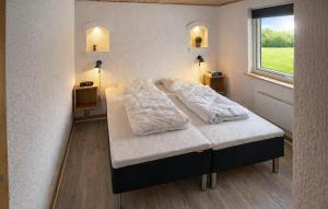 a bed in a room with two pillows on it at Nice Home In Oksbøl With Sauna in Oksbøl