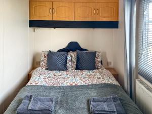 a bedroom with a bed with blue cabinets at Emily's Van in Skegness +5 photos