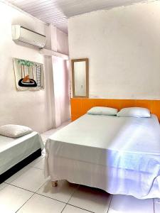 a bedroom with two beds and a mirror at Edifício AES Brasil in Cairu