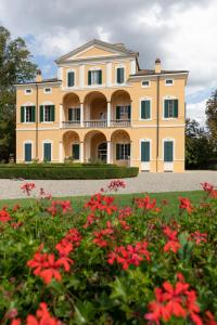 a large house with red flowers in front of it at Villa Simonetta in Parma
