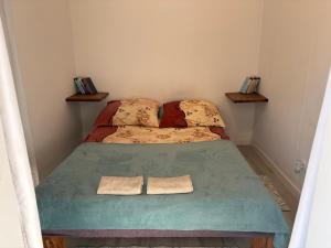 a small bedroom with a bed with two towels on it at Domek nad Strugą przy stawach 10 km od Warszawy" Jacuzzi na zamówienie" in Halinow
