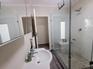 a white bathroom with a sink and a shower at GreenPeace in Stellenbosch