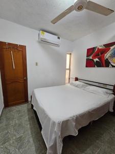 a bedroom with a bed and a ceiling fan at La Tribuna Lounge in Valledupar