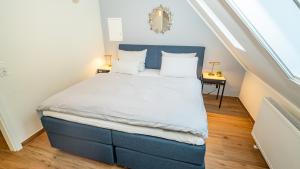 a bed with a blue headboard in a room at Erasmus 1901 Apartments in Trassem