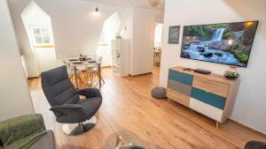 a living room with a television on a wall at Erasmus 1901 Apartments in Trassem
