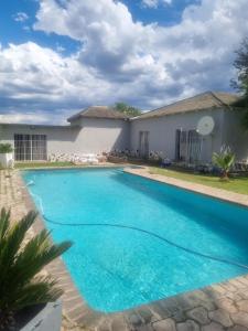 a swimming pool in front of a house at Lodge Linga Longa in Queenstown
