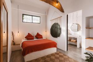 a bedroom with a bed with red sheets and a mirror at Casa Leone Villa Canggu by Summerhouse Bali in Canggu +22 photos