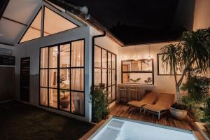 a home with a large window and a patio at Casa Leone Villa Canggu by Summerhouse Bali in Canggu