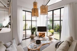a living room with a white couch and a table at Casa Leone Villa Canggu by Summerhouse Bali in Canggu