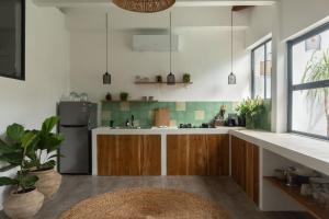 a kitchen with wooden cabinets and a refrigerator at Casa Leone Villa Canggu by Summerhouse Bali in Canggu