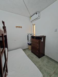 a small room with a bed and a dresser and a room with aropy at La Tribuna Lounge in Valledupar
