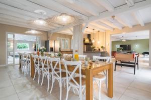 a dining room with a long table and white chairs at LA VILLA PALOMA in Crécy-la-Chapelle