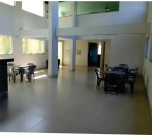 a room with tables and chairs in a building at Flats da Júnia, ótimo benefício, fácil check-in, wifi , tv, ar, garagem, localizacao in Lagoa Santa