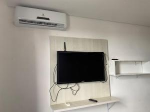 a flat screen tv hanging on a wall at Flats da Júnia, ótimo benefício, fácil check-in, wifi , tv, ar, garagem, localizacao in Lagoa Santa