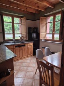a kitchen with wooden cabinets and a table and chairs at Escuelas de collía D AT-1537-AS in Arriondas