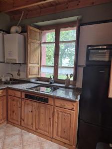 a kitchen with wooden cabinets and a black refrigerator at Escuelas de collía D AT-1537-AS in Arriondas +9 photos