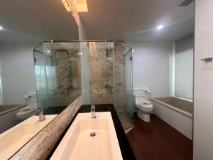 a bathroom with two sinks and a shower and a toilet at Boat Avenue Apartment in Bang Tao Beach