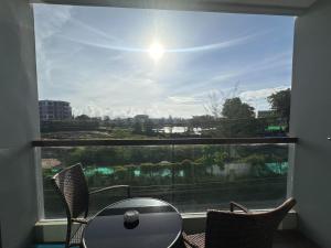 a room with a large window with a table and chairs at Boat Avenue Apartment in Bang Tao Beach