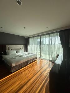 a bedroom with a bed and a large window at Boat Avenue Apartment in Bang Tao Beach