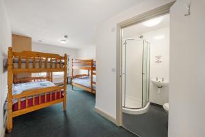 a bathroom with two bunk beds and a shower at Breakwater Hostel in Newquay