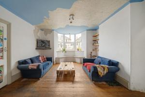 a living room with two blue couches and a table at Breakwater Hostel in Newquay
