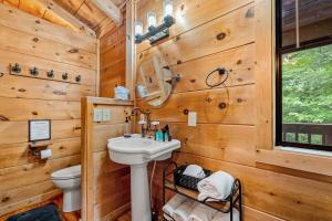 a bathroom with a sink and a toilet at Tennessee Whisper Cabin in Sevierville +21 photos