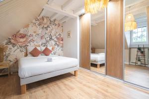 a bedroom with a bed with a floral wall at LA VILLA PALOMA in Crécy-la-Chapelle +50 photos