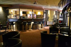 a bar in a restaurant with black chairs at Pension Schwarze Pumpe in Spremberg