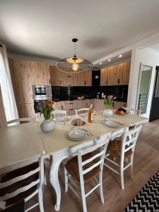 a kitchen with a large white table and chairs at Les Miracles du Ventoux in Malaucène