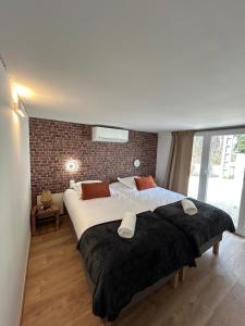 two beds in a bedroom with a brick wall at Les Miracles du Ventoux in Malaucène +38 photos
