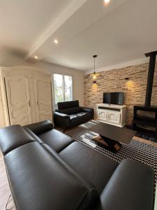 a living room with a couch and a tv at Les Miracles du Ventoux in Malaucène