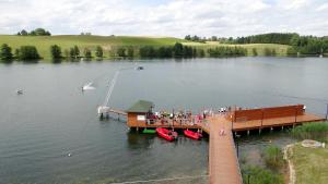 un grupo de personas en un muelle en un lago en WOSiR Szelment, en Jeleniewo