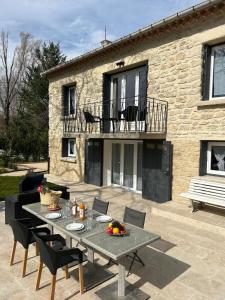 a patio with a table and chairs and a building at Les Miracles du Ventoux in Malaucène