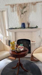 a living room with a table in front of a fireplace at Boreas Otel Alaçatı in Alaçatı