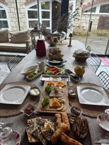 a wooden table with plates of food on it at Boreas Otel Alaçatı in Alaçatı +27 photos