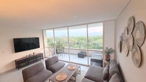 a living room with a couch and a large window at Citadela Di Sole Tropical Escape in Santa Fe de Antioquia