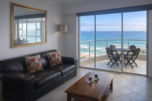 a living room with a couch and a table at Ocean View B1001, Blouberg in Bloubergstrand