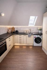 a kitchen with a sink and a washing machine at The Miles Arms Hotel in Avonmouth
