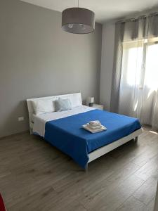 a bedroom with a bed with a blue blanket at Casa Punta d'Oro in Faccia di Trippa