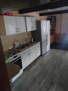 a kitchen with white cabinets and a white refrigerator at Chata Jablunka, Dog friendly, 50m ski slope, 50m restaurant in Pec pod Sněžkou