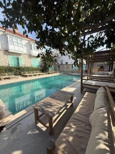 a swimming pool with a bench next to a building at Boreas Otel Alaçatı in Alaçatı