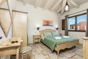 a bedroom with a bed and a desk and a window at Agorà Apartments in Villasimius +90 photos