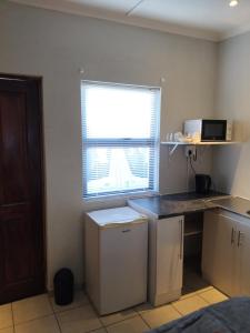 a kitchen with a counter and a window with a microwave at Overnight Lodge in Cape Town
