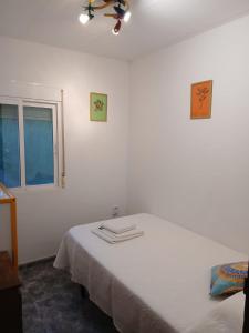 a white room with a bed with a window at L'Hortet de Can Serra in Xerta