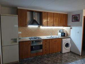 a kitchen with a sink and a stove top oven at L'Hortet de Can Serra in Xerta