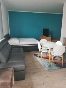 a living room with a couch and a table and chairs at 3 Ferienwohnungen am Teutoburger Wald in Natrup Hagen