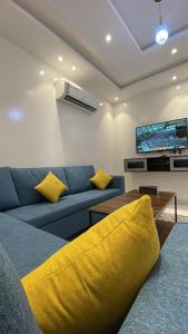 a living room with a blue couch and a tv at شقق ثمانين بارك1 in Khamis Mushayt