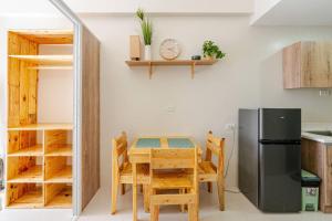 a kitchen with a wooden table and a refrigerator at Cozy and Nature-Inspired Studio Unit in Agus