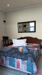 a large bed in a room with a mirror at Overnight Lodge in Cape Town